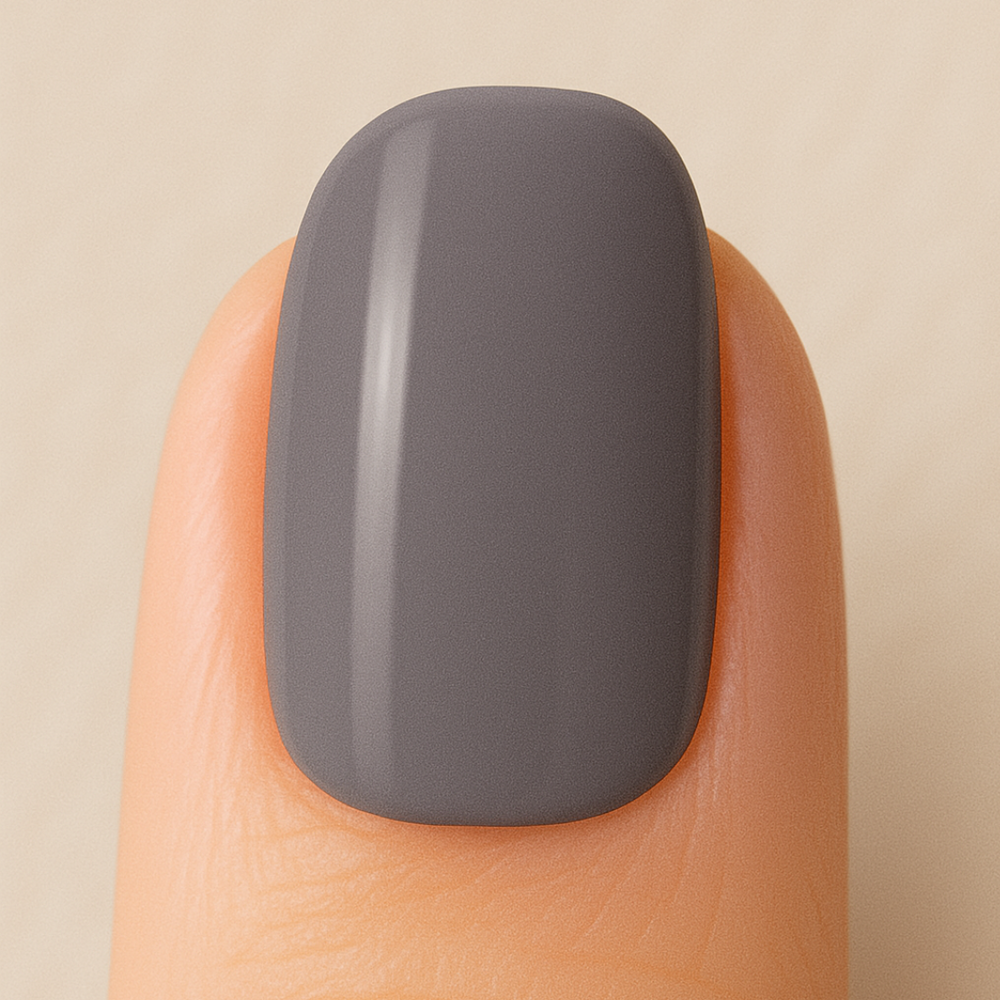 Gray gel polish on a finger against a beige background