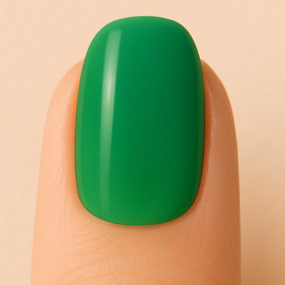 Green gel nail polish on a finger against a beige background