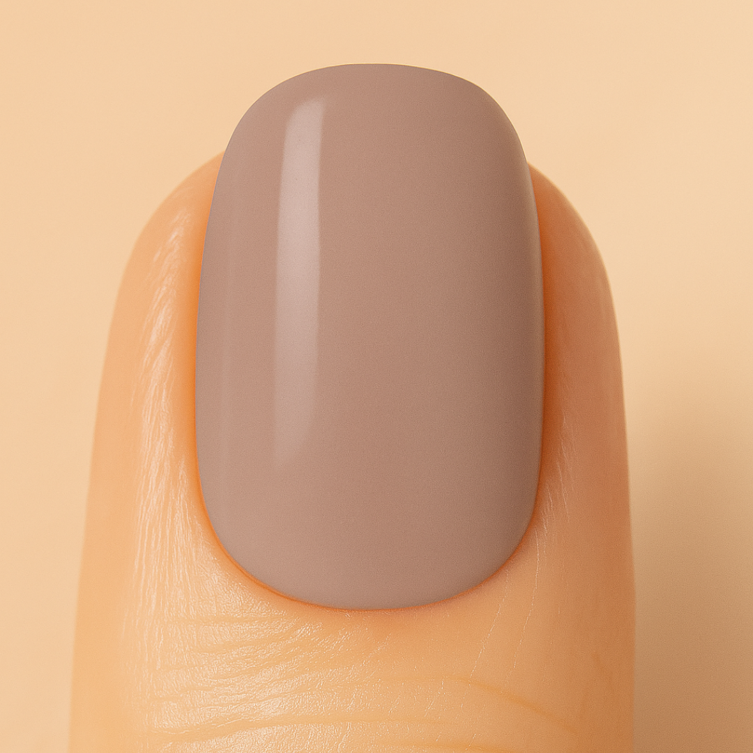 Latté coloured nail against a beige background