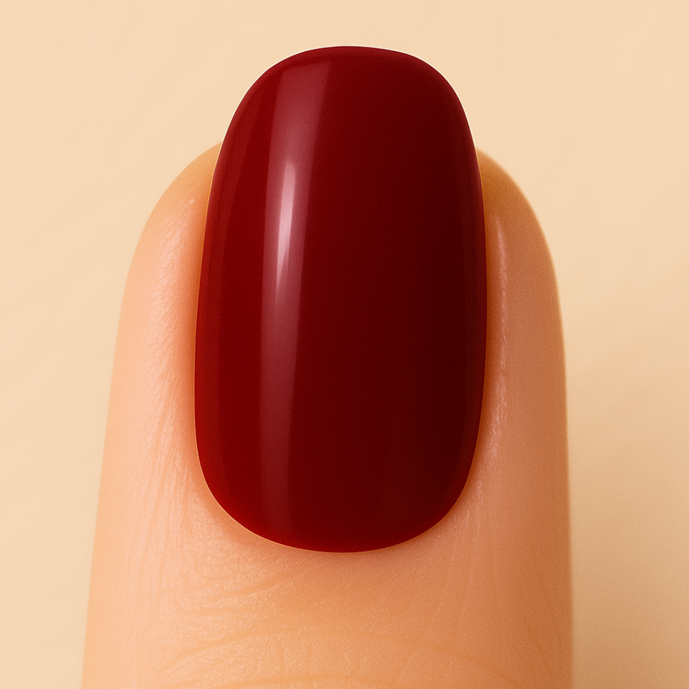 Red gel nail polish on a finger against a beige background