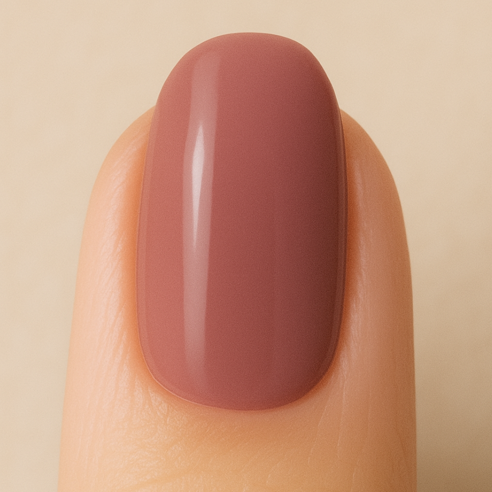 Nail with a smooth, mauve-colored gel polish on a beige background