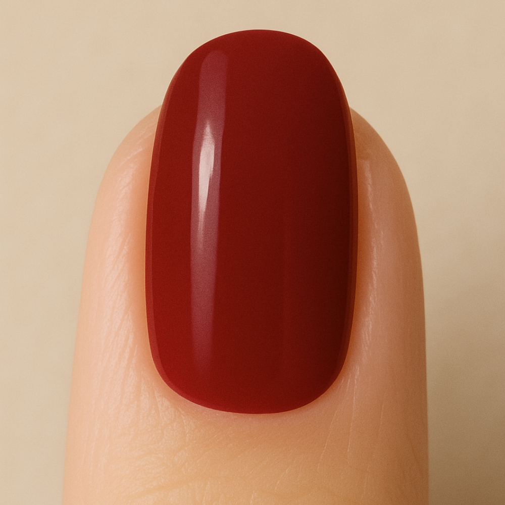 Red gel nail polish on a finger against a beige background