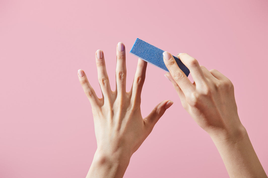 manikürte Hand mit nagel polierblock