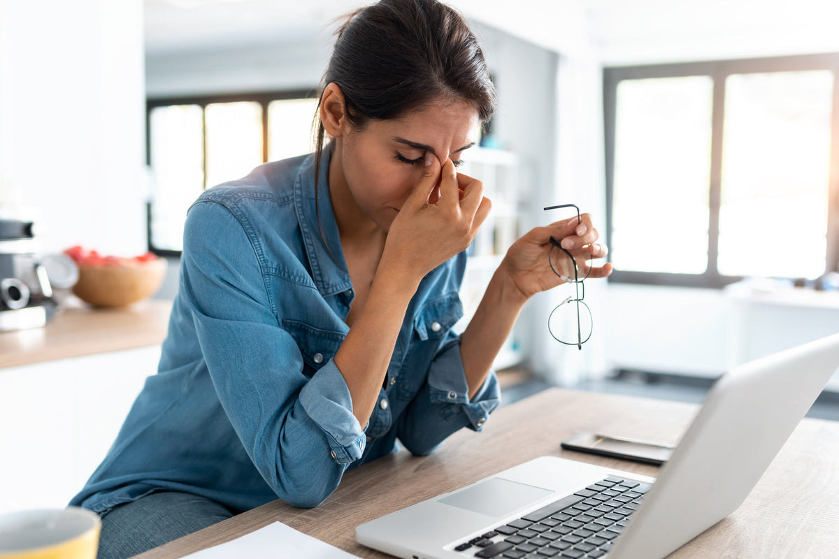 woman on laptop looking tired and drained