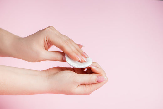 Frau entfernt Nagellack aus der Hand