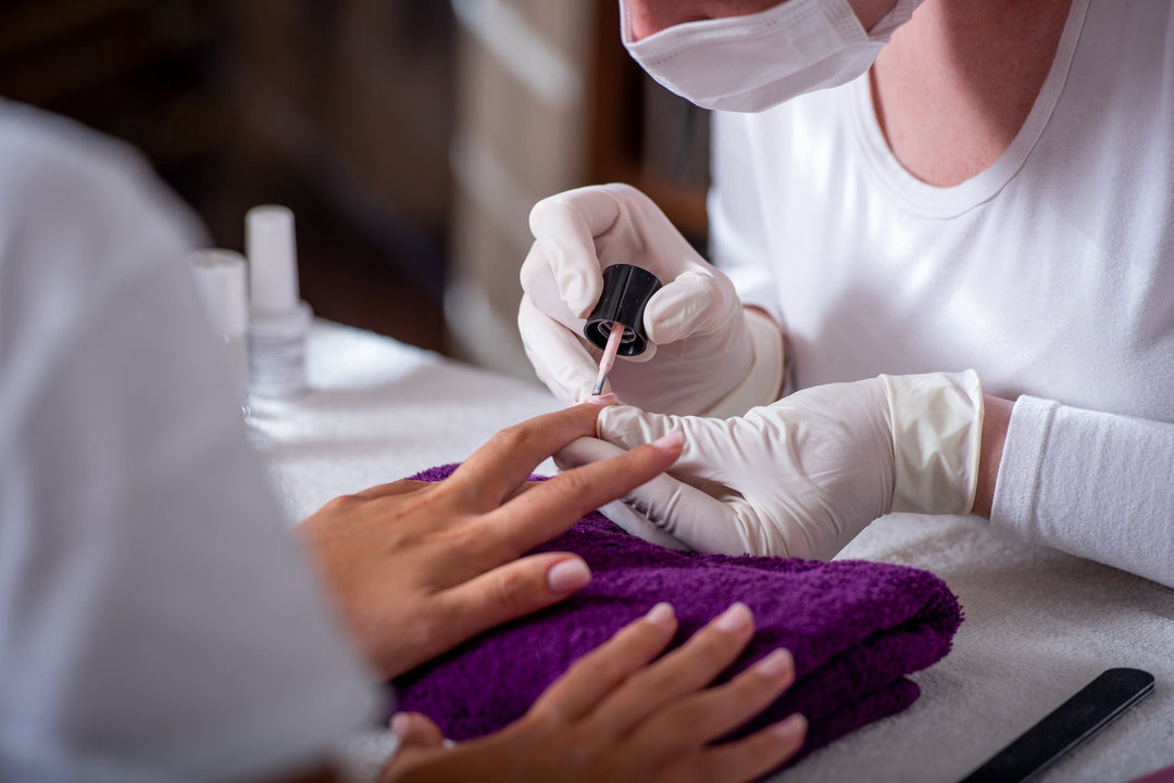 Nageldesignerin führt eine Maniküre durch