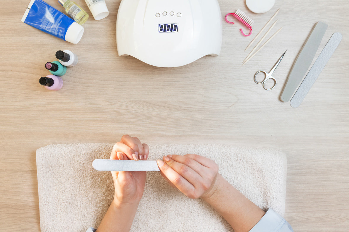 Manicura en casa con lima de uñas y herramientas.