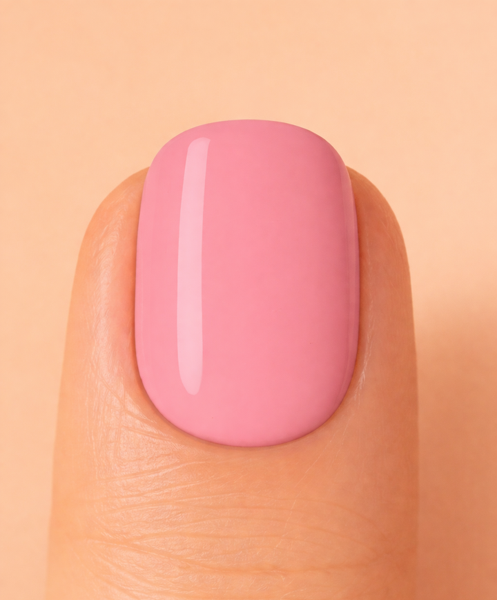 Close-up of a pink nail on a beige background