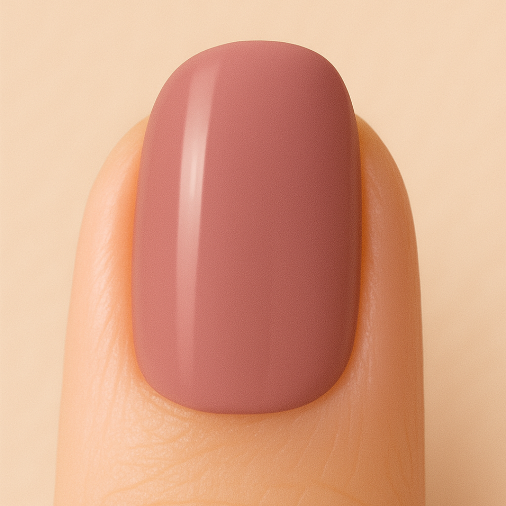 Light-brown gel nail polish colour on a nail against a beige background