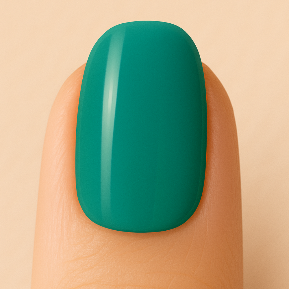 Green gel polish on a finger against a beige background