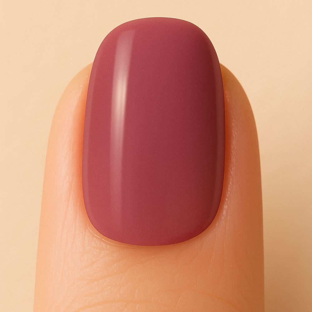 Nail with a glossy burgundy gel polish on a beige background