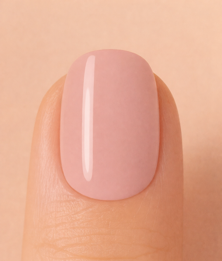 Nail with nude pink polish on a beige background