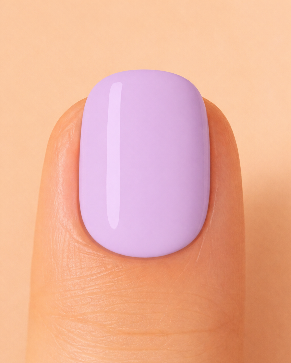 Close-up of a finger with a light purple nail on a peach background
