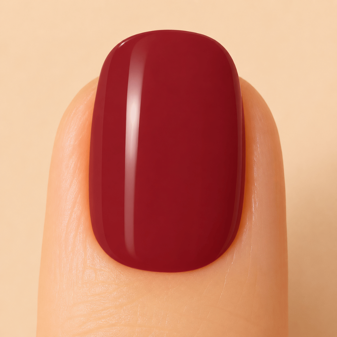 Close up image of a nail with burgundy gel nail polish applied.